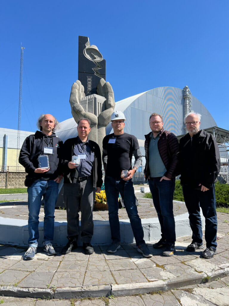 The Safecast/SaveDnipro/Blues Inc team in from of the Chornobyl NPP sarcophagus, May 8, 2024. From left to right: Pavlo Tkachenko, Azby Brown, Joe Moross, Neil Ozzie, Ray Ozzie