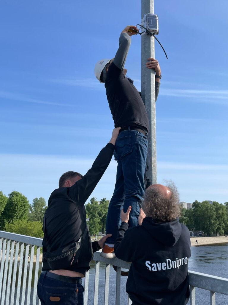 Safecast Lead Engineer Joe Moross gets assistance installing a Radnote realtime radiation detector in Kyiv, Ukraine, May 9, 2024
