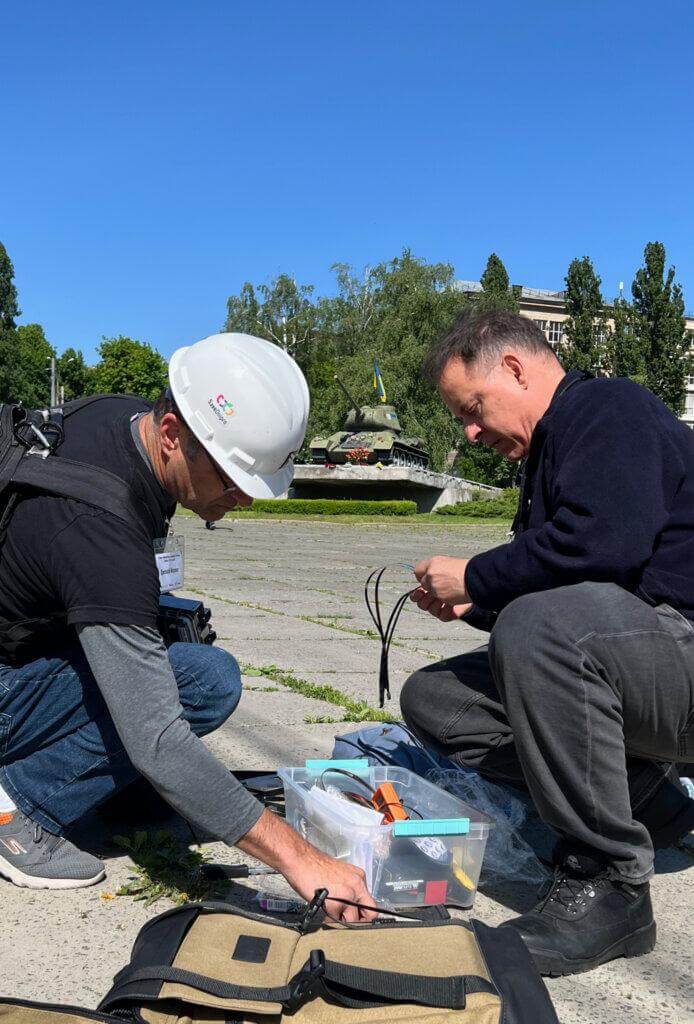 Safecast Lead Engineer Joe Moross (left) and Safecast Lead Researcher Azby Brown (right) prepare the installation of a Radnote realtime radiation detector in front of a war monument in Kyiv, Ukraine, May 9, 2024